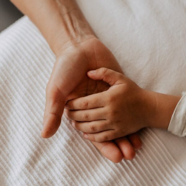 adult holding a child's hand