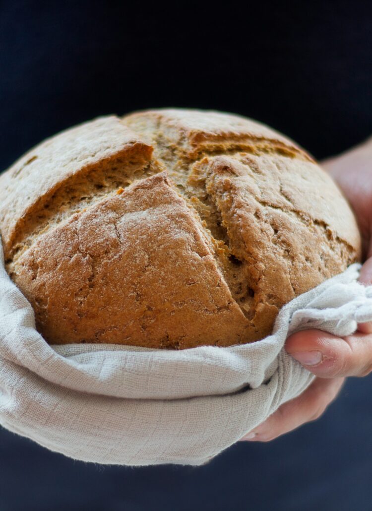 hands holding loaf of bread