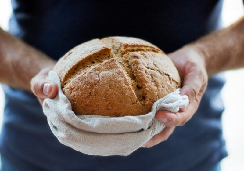 hands holding loaf of bread